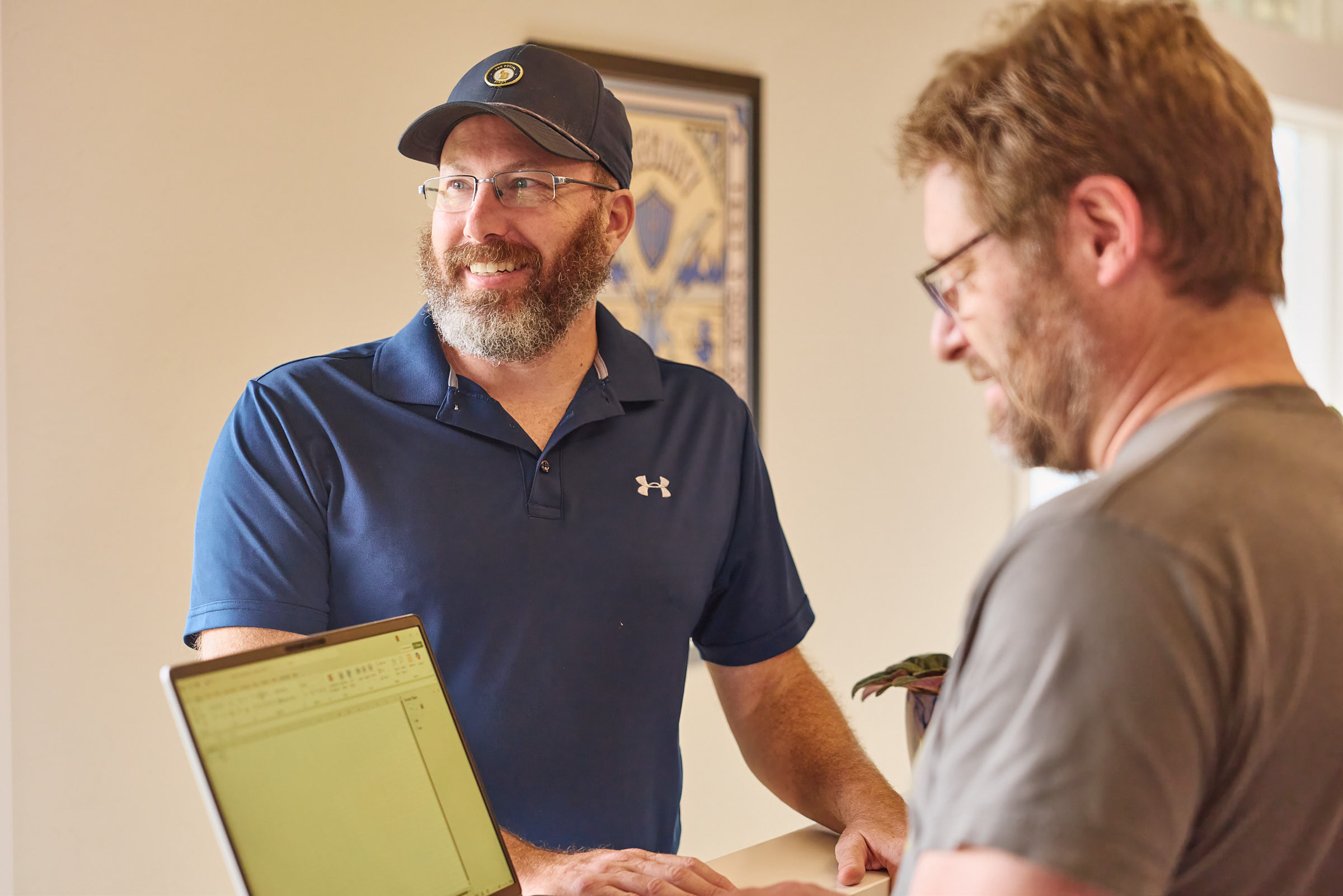 Two Mostly Serious team members mapping work beside a laptop.
