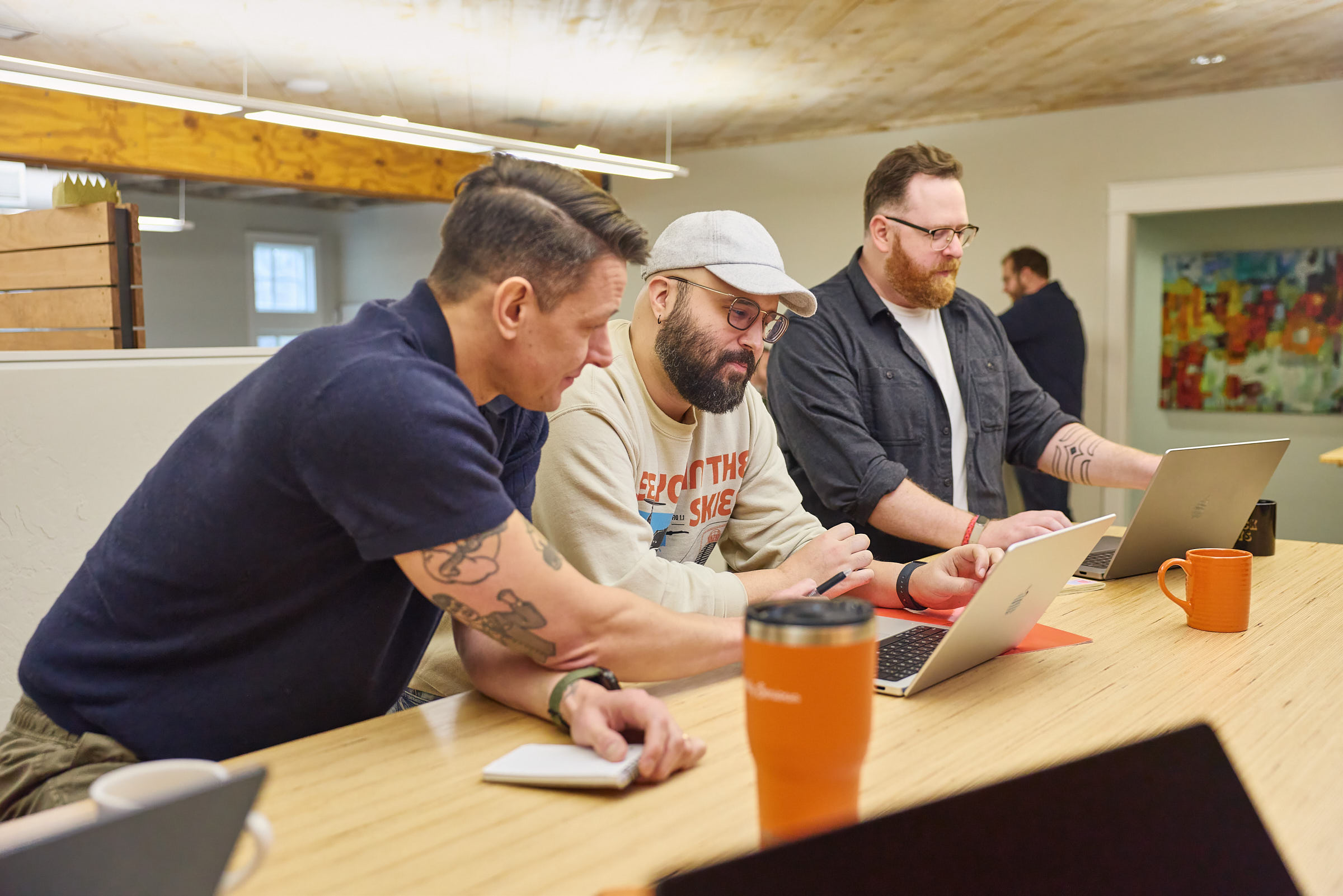 Three Mostly Serious team members collaborating at a standing table.