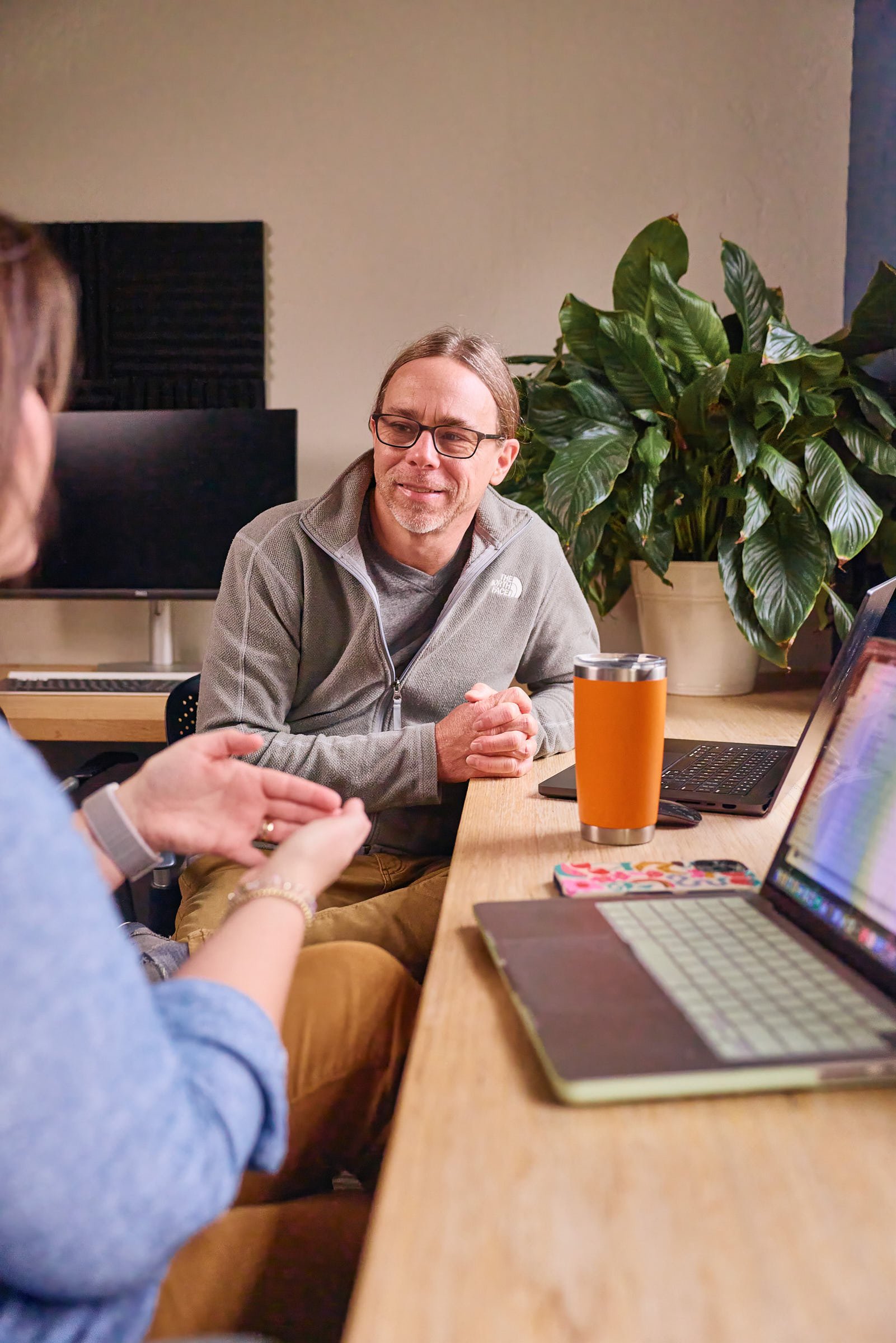 Mostly Serious team members discussing work together at a desk.